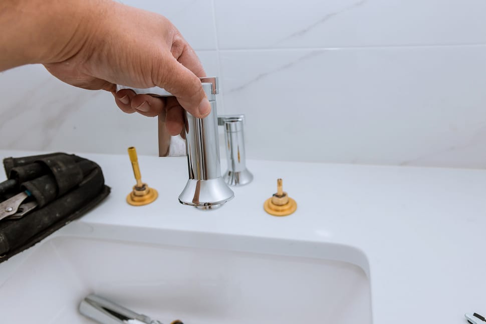 34116986 plumber installing new mixer tap hands worker close up repair in bathroom at home